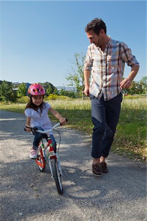 seeing - Father running next to daughter on bike Stock Photo - Rights-Managed, Code: 853-05840926