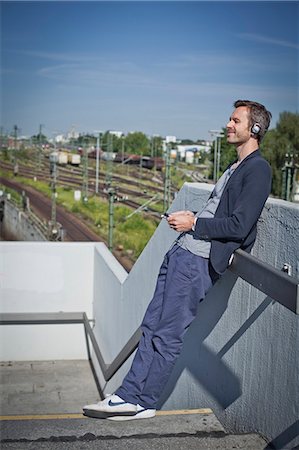 standing, headphones - Man with iphone Foto de stock - Con derechos protegidos, Código: 853-06120359