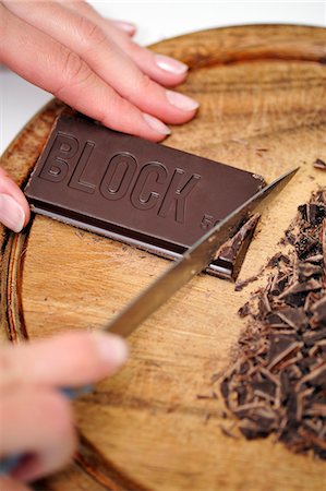 schokoriegel - Woman cutting chocolate Foto de stock - Con derechos protegidos, Código: 853-06306041