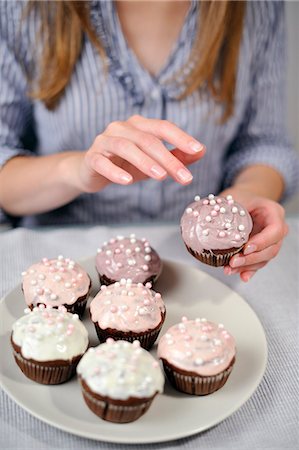 sustenance - Femme, mettre la garniture sur muffins sur plaque Photographie de stock - Rights-Managed, Code: 853-06306055