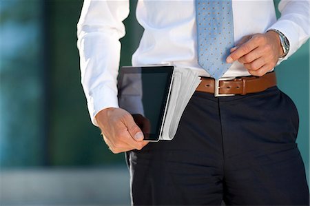 Businessman carrying tablet PC and newspaper under his arm Stock Photo - Rights-Managed, Code: 853-06441616