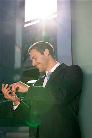 simsearch:853-06441321,k - Happy businessman looking at cell phone outdoors Stock Photo - Rights-Managed, Code: 853-06441619