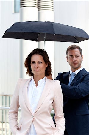 simsearch:853-03616797,k - Businessman holding umbrella above businesswoman Stock Photo - Rights-Managed, Code: 853-06441698