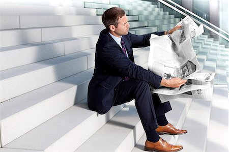 economy newspaper - Businessman reading newspaper on stairs Stock Photo - Rights-Managed, Code: 853-06441707