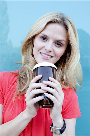 relógio de pulso - Smiling blond woman holding coffee to go Foto de stock - Direito Controlado, Número: 853-06441758