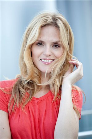 Smiling blond woman wearing red top Foto de stock - Con derechos protegidos, Código: 853-06441770