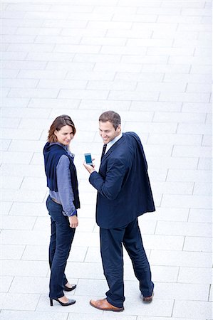 simsearch:853-05523421,k - Businessman and businesswoman standing with cell phone outdoors Stock Photo - Rights-Managed, Code: 853-06441792