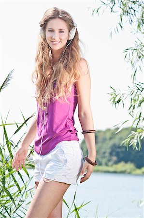 Blond young woman listening to music at a lake Stock Photo - Rights-Managed, Code: 853-06442061