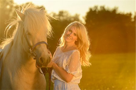 simsearch:853-07241787,k - Lächelnde Frau in weißen Kleid mit Pferd auf der Wiese Stockbilder - Lizenzpflichtiges, Bildnummer: 853-06442132