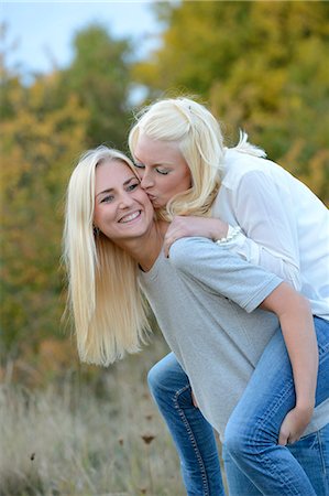 Happy young blond woman carrying her friend piggyback Stock Photo - Rights-Managed, Code: 853-06442232