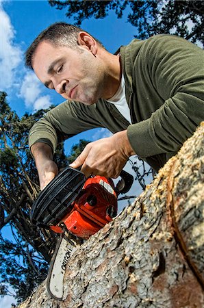 emotional man - Man sawing log Stock Photo - Rights-Managed, Code: 853-06623201