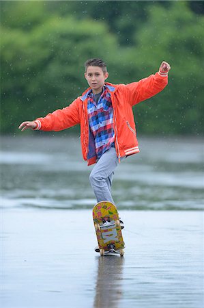 energy concept fun - Boy with skateboard on a rainy day Stock Photo - Rights-Managed, Code: 853-07148622