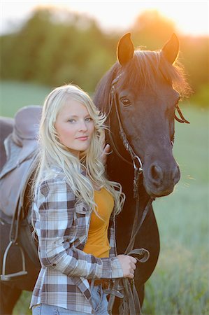 sun set of animal - Young woman standing beside a horse on a meadow at sunset Foto de stock - Con derechos protegidos, Código: 853-07148638