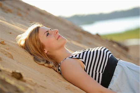 simsearch:853-06442228,k - Young woman wearing dress lying on beach Stockbilder - Lizenzpflichtiges, Bildnummer: 853-07148656