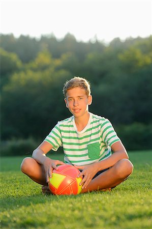 f1online - Teeange boy sitting with football on meadow, Upper Palatinate, Bavaria, Germany, Europe Photographie de stock - Rights-Managed, Code: 853-07241763