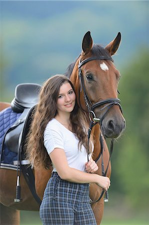 pubertad - Teenage girl standing with a Mecklenburger horse on a paddock Foto de stock - Con derechos protegidos, Código: 853-07241784