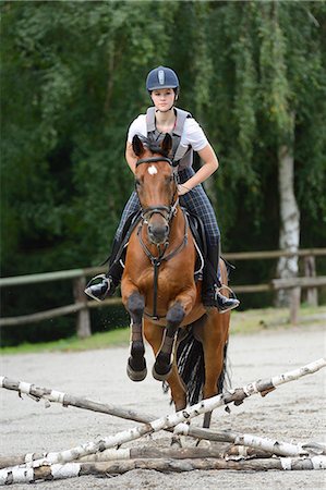 Teenage girl jumping with a Mecklenburger horse on a riding place Photographie de stock - Rights-Managed, Code: 853-07241789