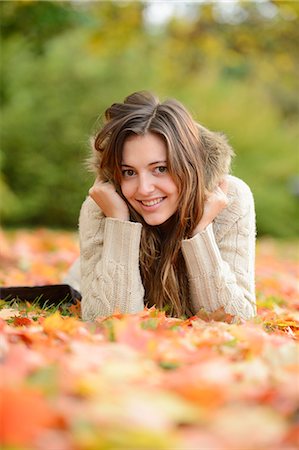 simsearch:853-07026687,k - Smiling young woman lying in autumn leaves Stock Photo - Rights-Managed, Code: 853-07241894