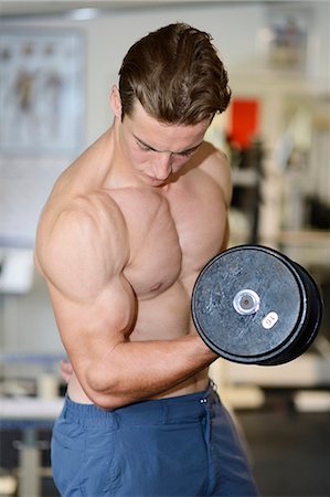Young man exercising in fitness center Foto de stock - Con derechos protegidos, Código: 853-07241928