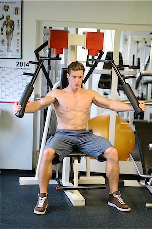 Young man exercising in fitness center Stock Photo - Rights-Managed, Code: 853-07241934