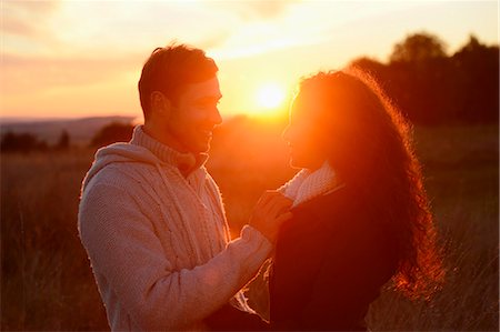 Couple at sunset on field Stockbilder - Lizenzpflichtiges, Bildnummer: 853-07241957