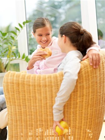 people eating bagels - Two girls sitting in armchair Stock Photo - Rights-Managed, Code: 853-02914035