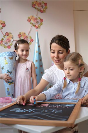 friends women indoors happy middle aged - Mother and children writing on blackboard Stock Photo - Rights-Managed, Code: 853-02914356