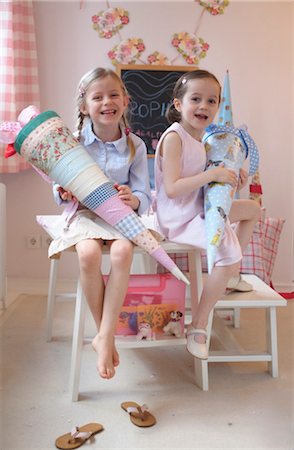 female front shot - Two girls with cardboard cone sitting in table Stock Photo - Rights-Managed, Code: 853-02914365