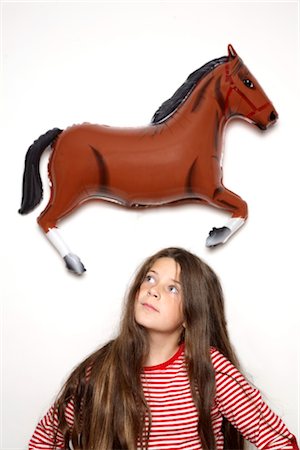 photos for a girl 10 years - Girl with long dark hair standing under plastic horse Stock Photo - Rights-Managed, Code: 853-02913631