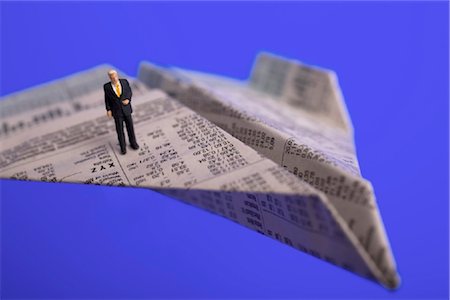 High angle view of figurine of businessman standing on paper airplane Stock Photo - Rights-Managed, Code: 853-03227721