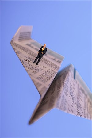 High angle view of figurine of businessman standing on paper airplane Stock Photo - Rights-Managed, Code: 853-03227722