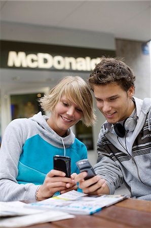 simsearch:853-03458858,k - Two teenagers looking at their mobile phones, front view Foto de stock - Con derechos protegidos, Código: 853-03458836