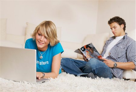 Teenager couple using media in living room, slanted view Foto de stock - Con derechos protegidos, Código: 853-03458850