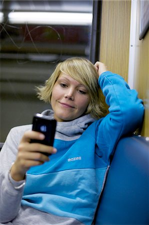 simsearch:853-03458858,k - Young woman using mobile phone in city train, front view Foto de stock - Con derechos protegidos, Código: 853-03458851