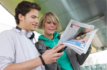 simsearch:853-03458858,k - Teenager couple reading newspaper on the go, view from below Foto de stock - Con derechos protegidos, Código: 853-03458864