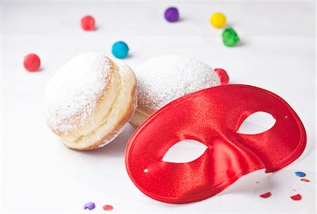 Red carnival mask, doughnuts and confetti, close-up Foto de stock - Con derechos protegidos, Código: 853-03458965