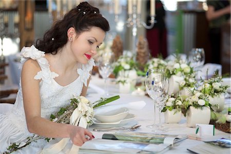 Bride sitting at a table, looking in a magazine Stock Photo - Rights-Managed, Code: 853-03459050