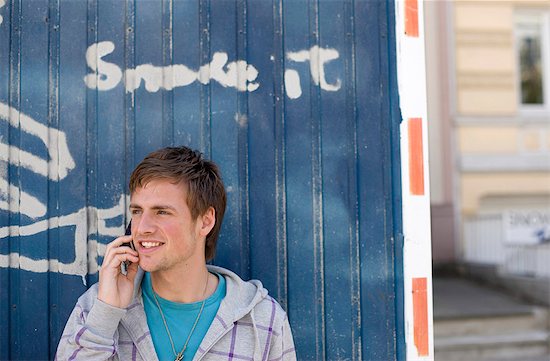 Young man with mobile phone standing in front of a container Stock Photo - Premium Rights-Managed, Artist: F1Online, Image code: 853-03459079