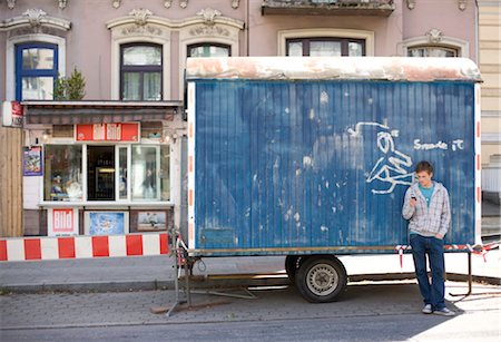 road block - Young man standing in front of an old trailer Stock Photo - Rights-Managed, Code: 853-03459081