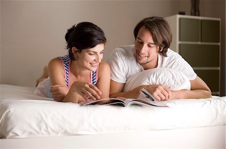 Man and woman reading a magazine on bed, low angle view Stock Photo - Rights-Managed, Code: 853-03459091