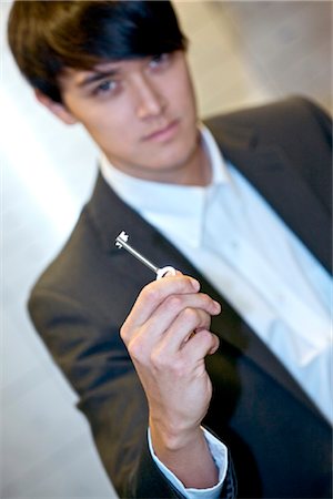 Man holding key for safe deposit box Foto de stock - Con derechos protegidos, Código: 853-03616832