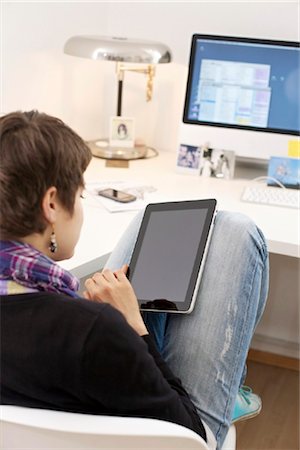 sit on top of desk - Young woman using iPad Stock Photo - Rights-Managed, Code: 853-03616843