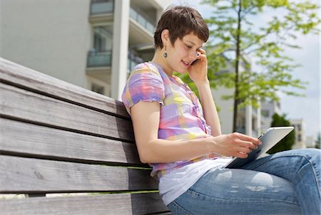 easing - Young woman with cell phone and iPad on a bench Stock Photo - Rights-Managed, Code: 853-03616865