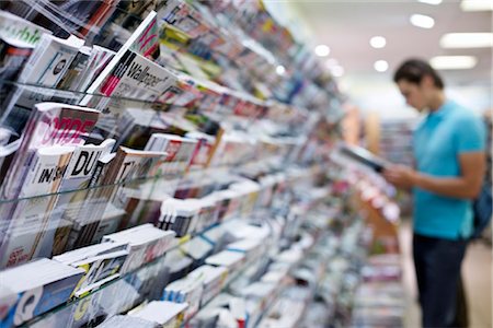 full picture of a man - Young man reading magazine in shop Stock Photo - Rights-Managed, Code: 853-03616894