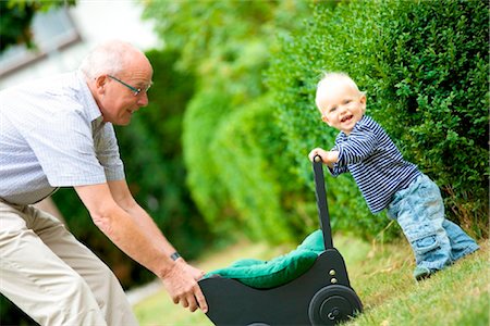 plié - Grand-père et enfant en bas âge avec landau de poupée en plein air Photographie de stock - Rights-Managed, Code: 853-03616915