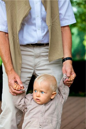 Grandfather helping toddler to walk Stock Photo - Rights-Managed, Code: 853-03616945