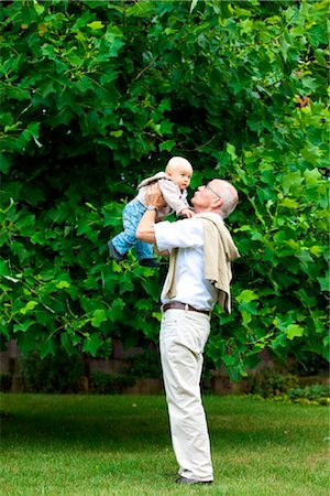 Grandfather carrying toddler outdoors Stock Photo - Rights-Managed, Code: 853-03616951