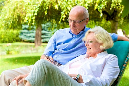 Happy senior couple with smartphone in garden Fotografie stock - Rights-Managed, Codice: 853-03616965