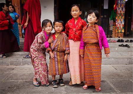 simsearch:862-05997048,k - Enfants dans des costumes traditionnels bhoutanais au Chorten commémoratif National, qui a été construit dans le style tibétain en 1974 pour honorer le troisième roi du Bhoutan. Photographie de stock - Rights-Managed, Code: 862-05996921
