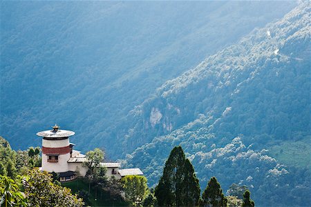 simsearch:862-05997034,k - Bei einem strategischen Aussichtspunkt hoch oben über Trongsa Dzong erhebt sich der Wachturm, der Ta Dzong. Der Ta Dzong ist heute ein Museum, gewidmet der Herrscher von Bhutan. Stockbilder - Lizenzpflichtiges, Bildnummer: 862-05996979